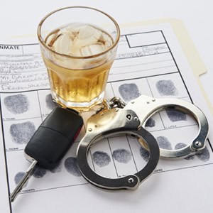 A glass of alcohol, car key and handcuffs symbolizing DUI Offense