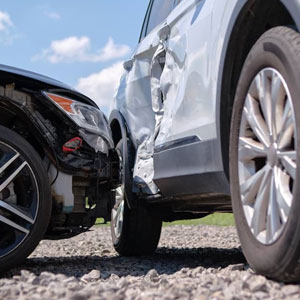 A damaged car after a collision, showing dented bodywork and shattered glass.